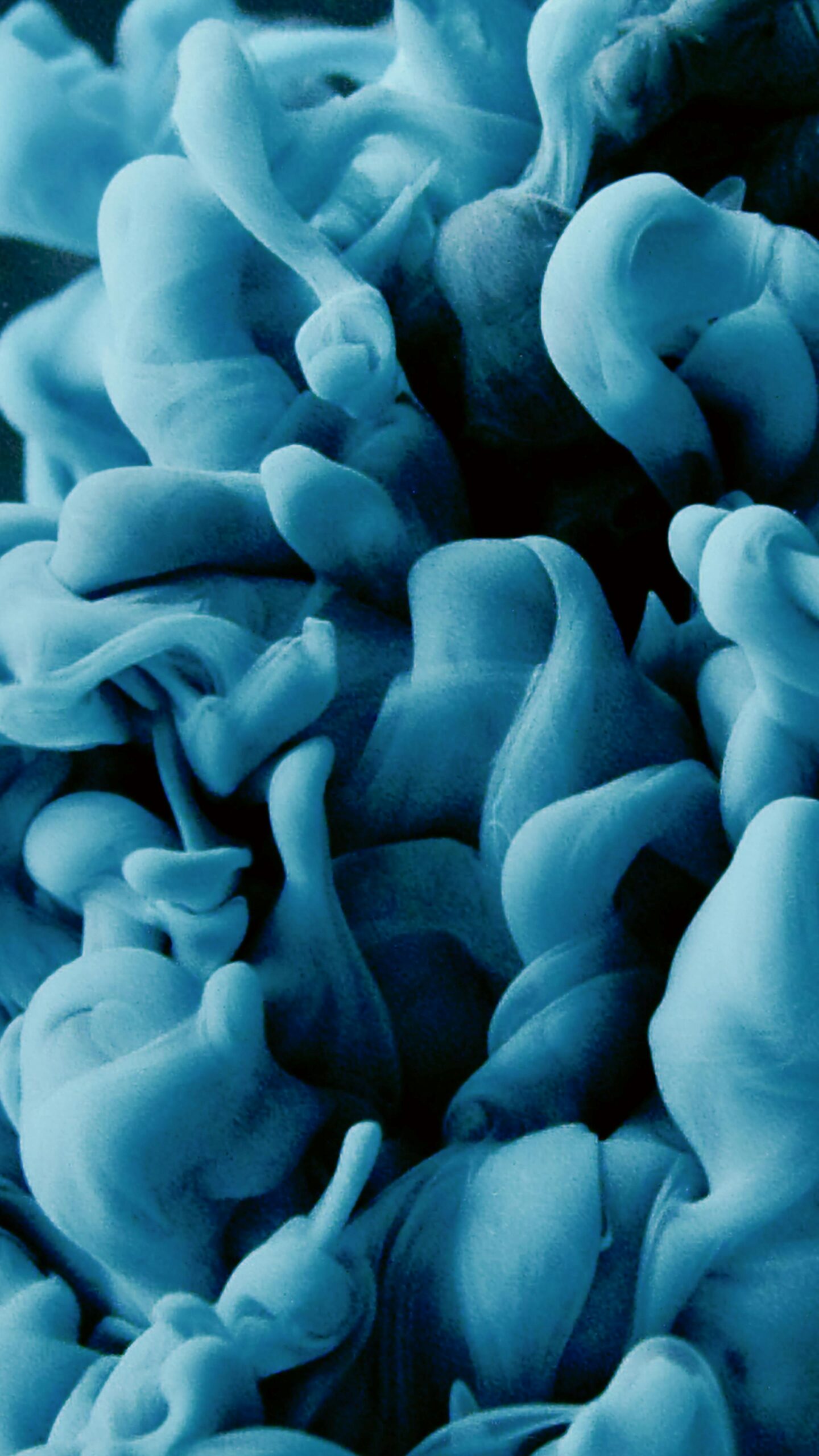 Close-up abstract of blue-colored liquid swirls in dynamic motion, creating a vibrant and artistic pattern.